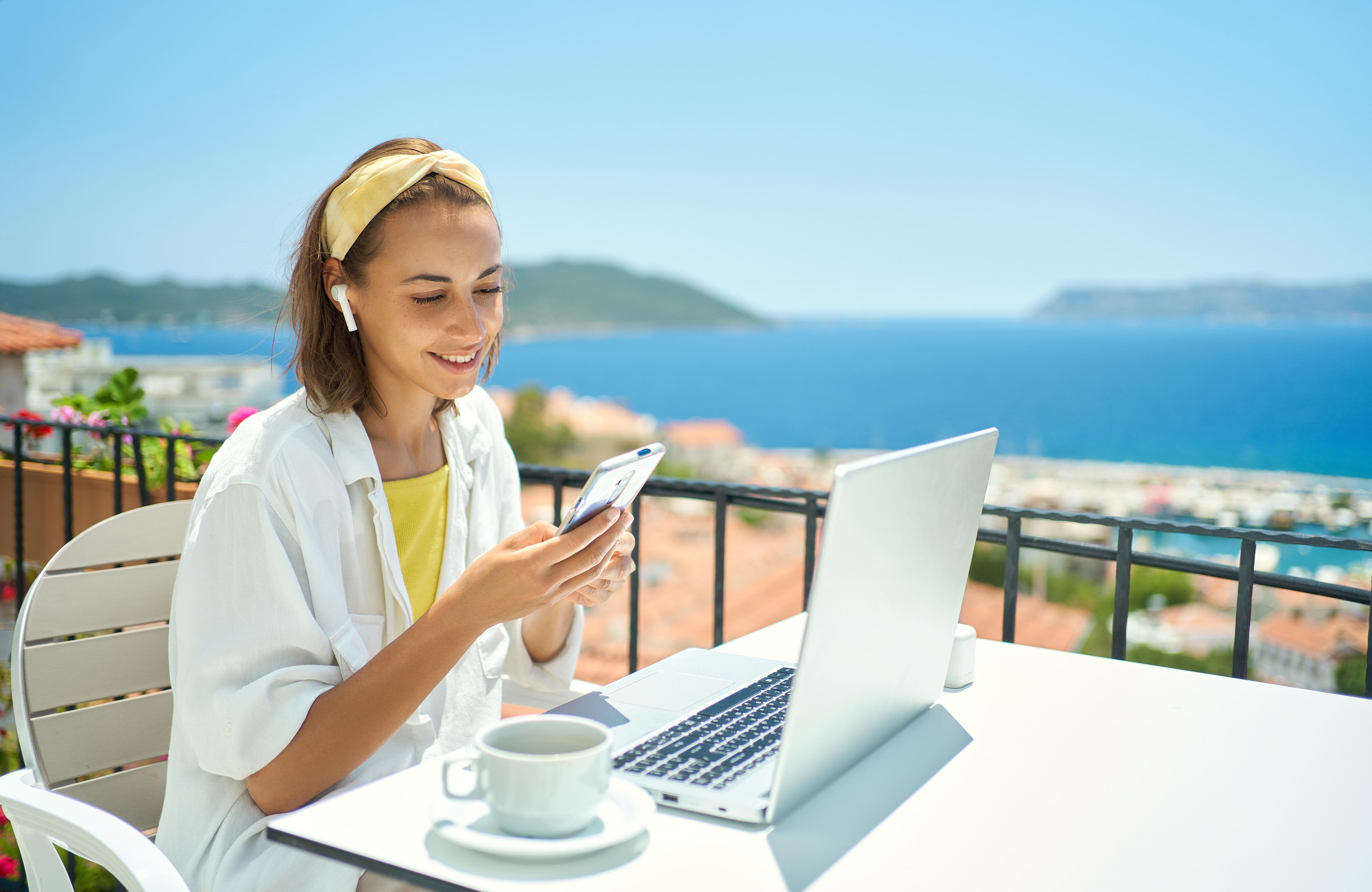 Hospitality professional reviewing guest messages on a laptop and phone