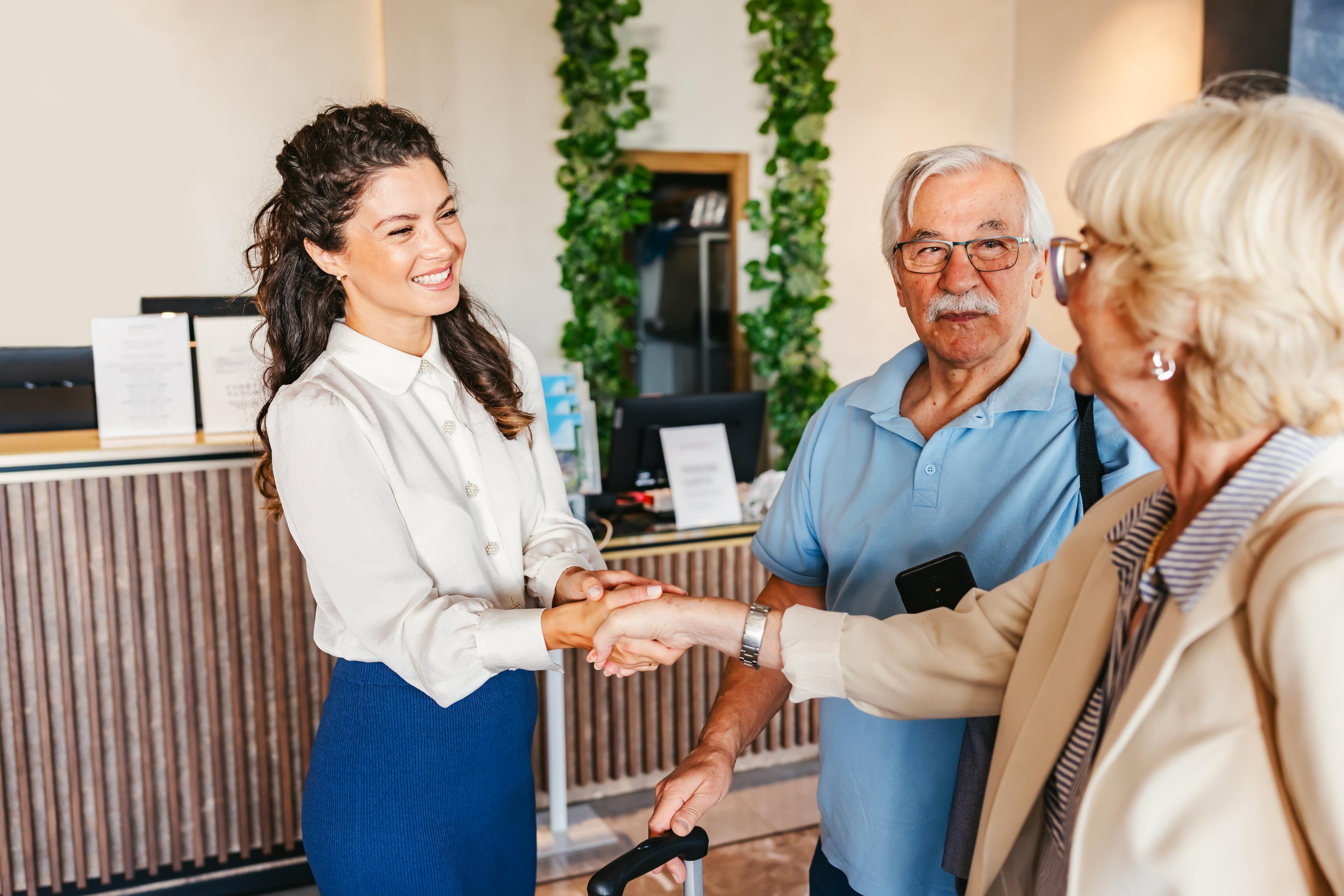 Hotel host warmly welcoming two guests